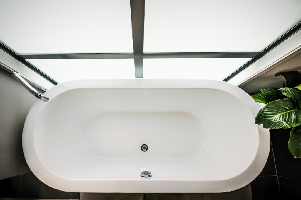 bathtub in front of large bathroom window