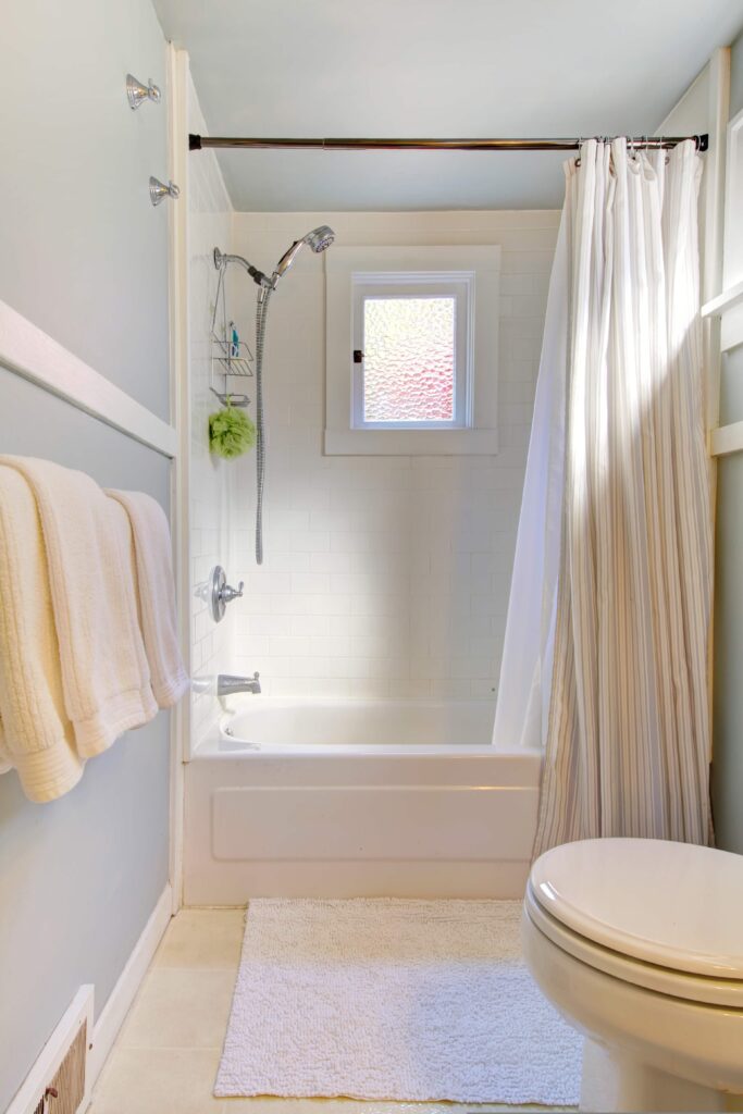 small blue bathroom with tub shower combo