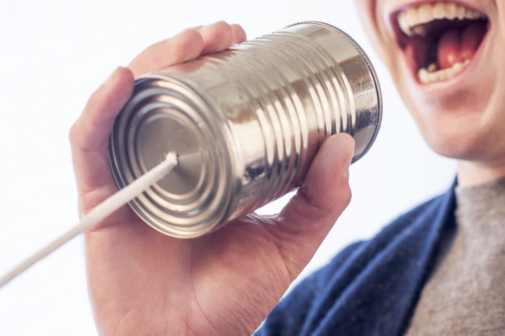 man screaming into a tin can